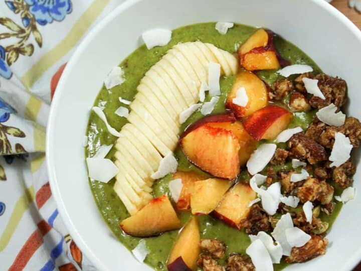 Peaches n Kale Smoothie Bowl Recipe - A delicious peaches n' cream smoothie bursting with antioxidants and protein. Topped with fruit and wholesome granola, it's a perfect way to start the day or treat yourself at night.