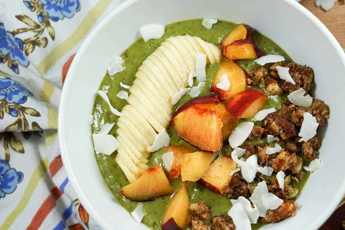 Peaches n Kale Smoothie Bowl Recipe - A delicious peaches n' cream smoothie bursting with antioxidants and protein. Topped with fruit and wholesome granola, it's a perfect way to start the day or treat yourself at night.