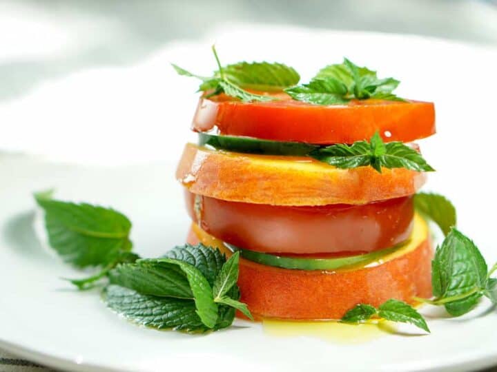 Peach Tomato Mint Salad Stack Recipe - Simply slice fresh peaches, tomatoes and cucumbers, stacking with mint to create this great appetizer, light meal or side salad. This will definitely be a recipe to impress your friends at your next barbq or family dinner!