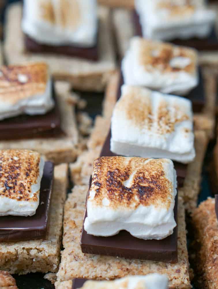 Paleo smores cookie bars with individual cookie bars topped with chocoalte and toasted homemade marshmallows.