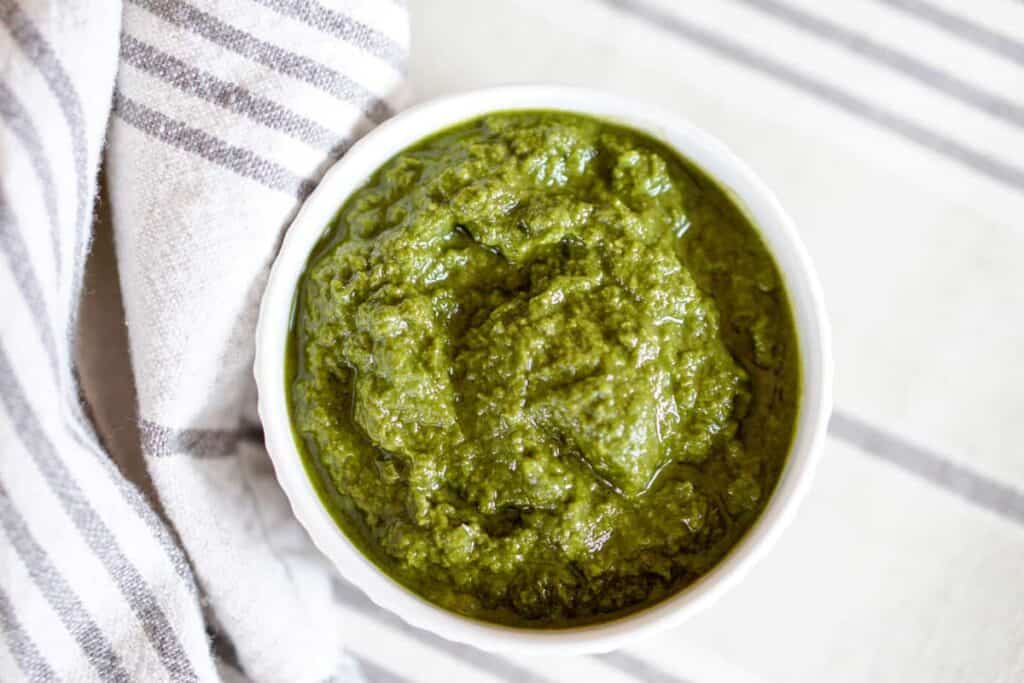 This Awesome Kale Green Sauce recipe is packed with delicious nutritious greens. 5 ingredients, 5 minutes. Use for a healthy kick on Pizza, Salads, + fries.