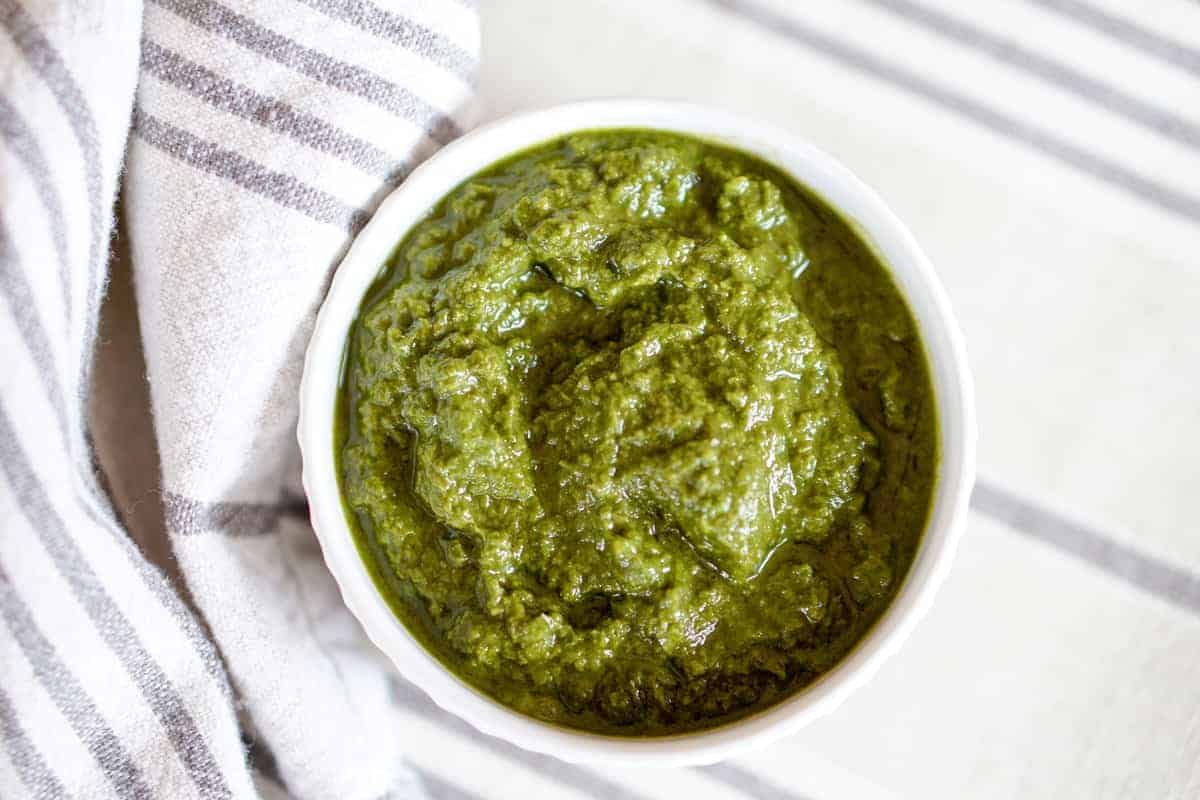 This Awesome Kale Green Sauce recipe is packed with delicious nutritious greens. 5 ingredients, 5 minutes. Use for a healthy kick on Pizza, Salads, + fries.