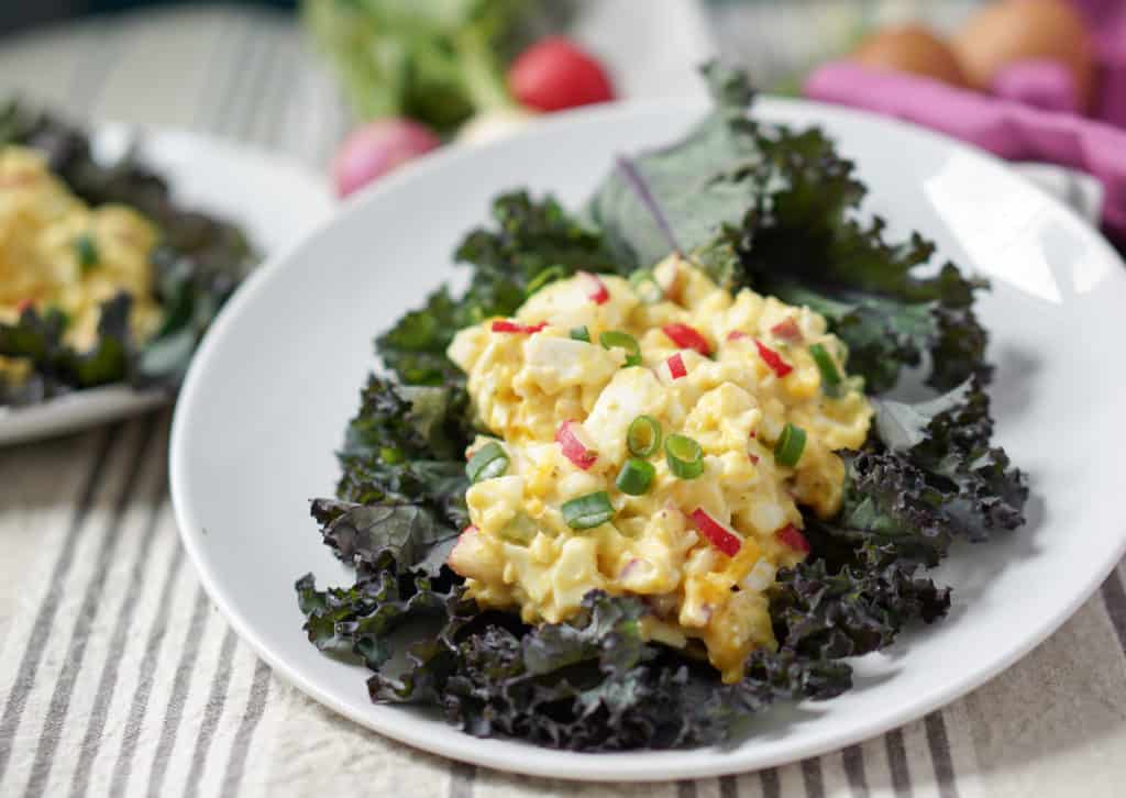 A cleaned up and simple 5 ingredient Egg Salad Kale Wraps recipe: pasture raised eggs, paleo mayo, fresh radishes and green onions all wrapped in Red Kale