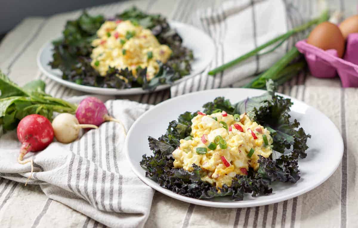 A cleaned up and simple 5 ingredient Egg Salad Kale Wraps recipe: pasture raised eggs, paleo mayo, fresh radishes and green onions all wrapped in Red Kale