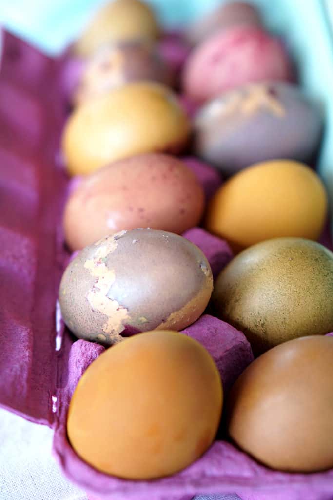 Multi colored eggs for Easter in a pink egg carton