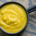 Simple blended 10 minute pumpkin soup with coconut milk and tahini in a black mug. GLuten free, dairy free, whole 30, paleo, and keto