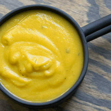 Simple blended 10 minute pumpkin soup with coconut milk and tahini in a black mug. GLuten free, dairy free, whole 30, paleo, and keto