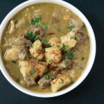 Warming Purple potato halibut curry with cardamom basmati in white bowl on a black background