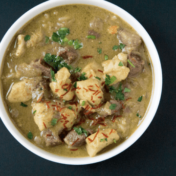 Warming Purple potato halibut curry with cardamom basmati in white bowl on a black background