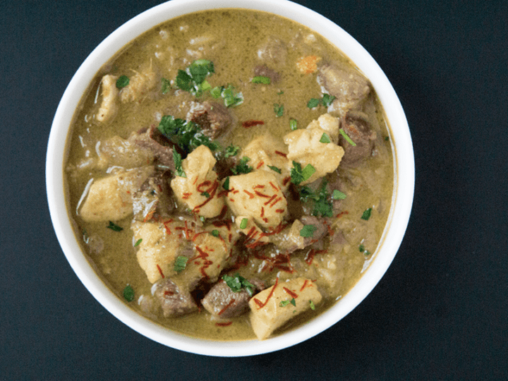 Warming Purple potato halibut curry with cardamom basmati in white bowl on a black background