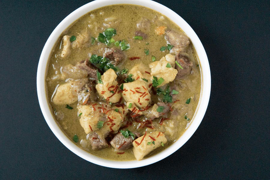 Warming Purple potato halibut curry with cardamom basmati in white bowl on a black background