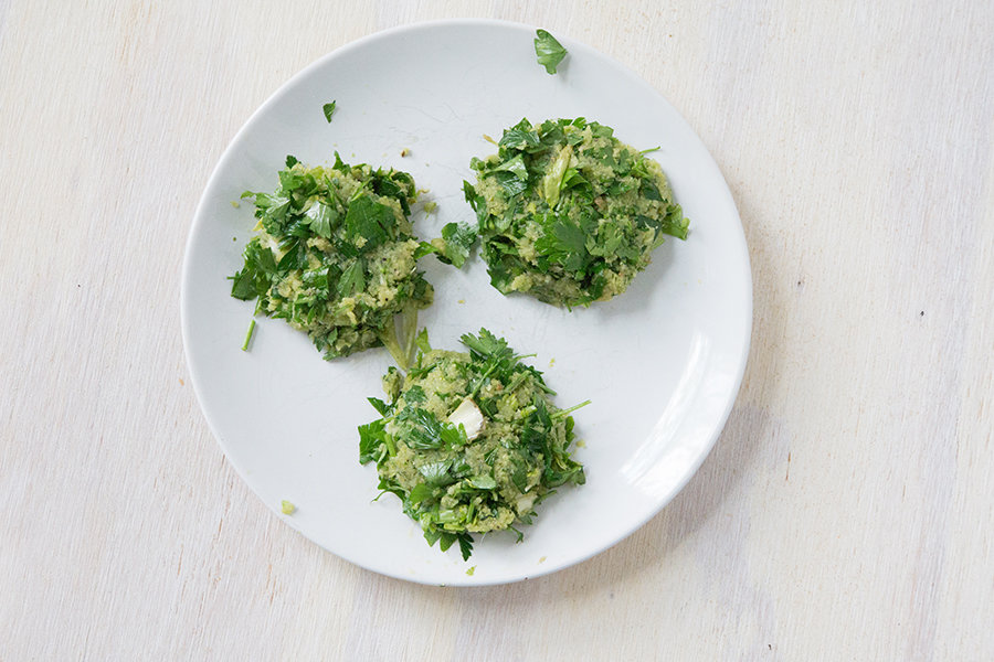 uncooked celery pulp and parsley patties on a white plate