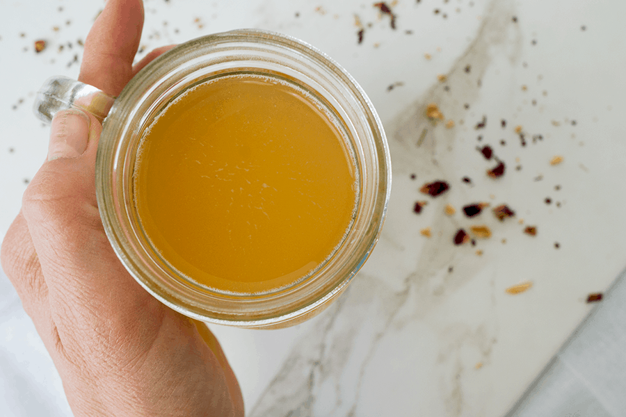 Home brewed Jun, a honey and green tea version of kombucha, in mason jar on marble