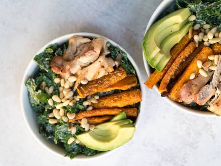 Superfood Kale Caesar salad with avo, chicken thighs, pine nuts, and creamy tahini cashew Caesar dressing