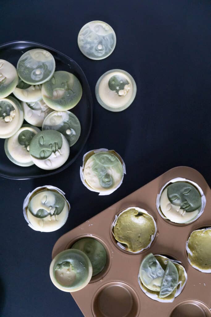 Mini Moringa Cheesecakes with White Chocolate Moons on black with muffin tin