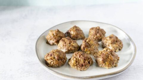 White plate with meatballs on cement surface