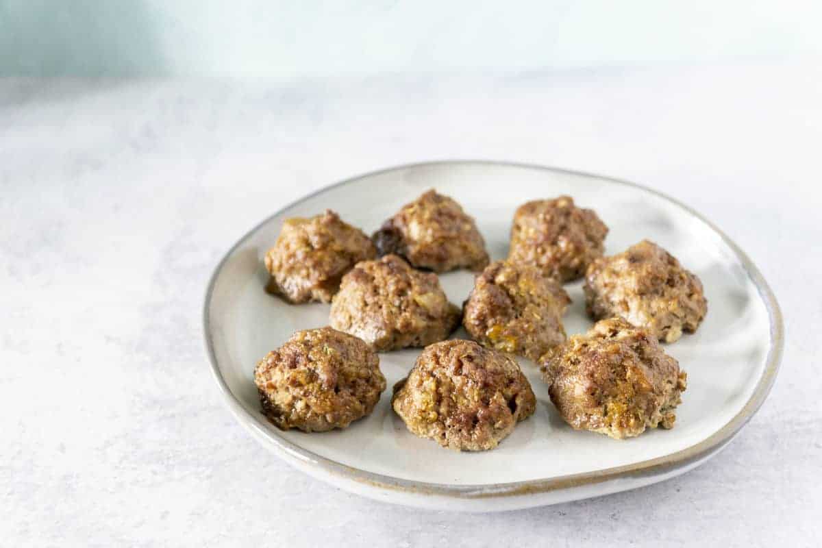 White plate with meatballs on cement surface